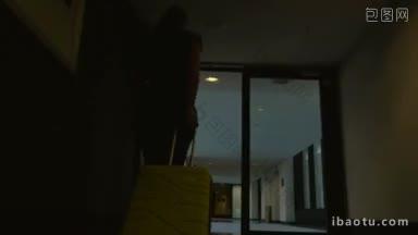 斯坦尼康和低角度拍摄的一个女人走在<strong>酒店</strong>走廊与黄色的手推车包